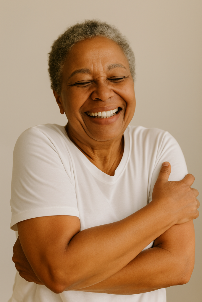 Older woman hugging herself with joy, symbolizing the power of self-love”